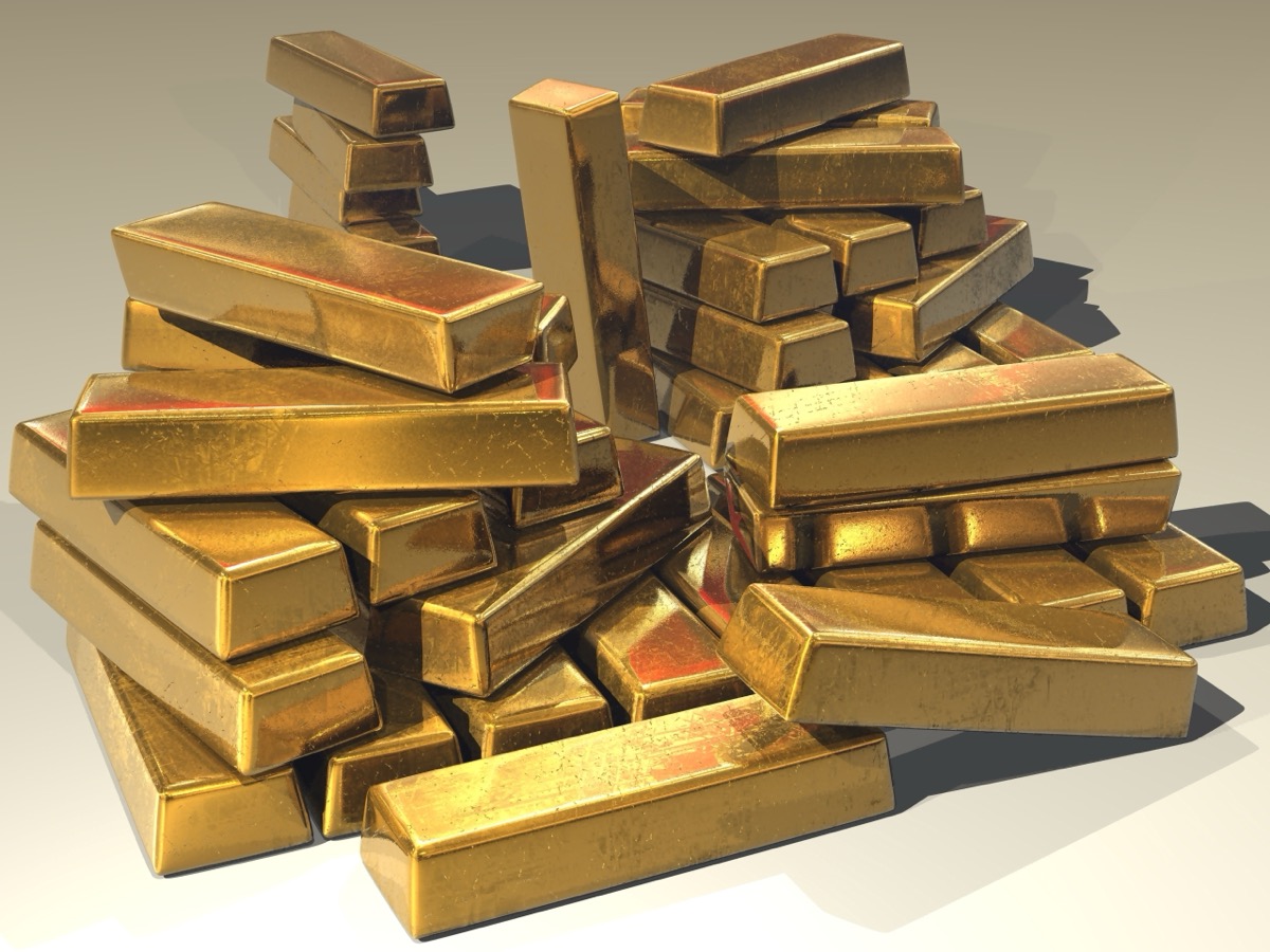 Stacked gold bullion bars, the physical metal that backs tokenized gold like Tether Gold