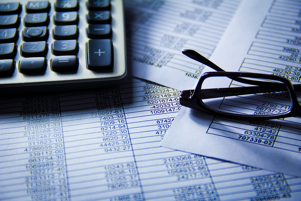 Financial statements and figures on paper, representing private credit collateral behind a tokenized dollar